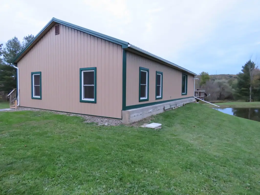 House resided with Saddle Tan steel siding and Ivy Green trim_Springwater, NY